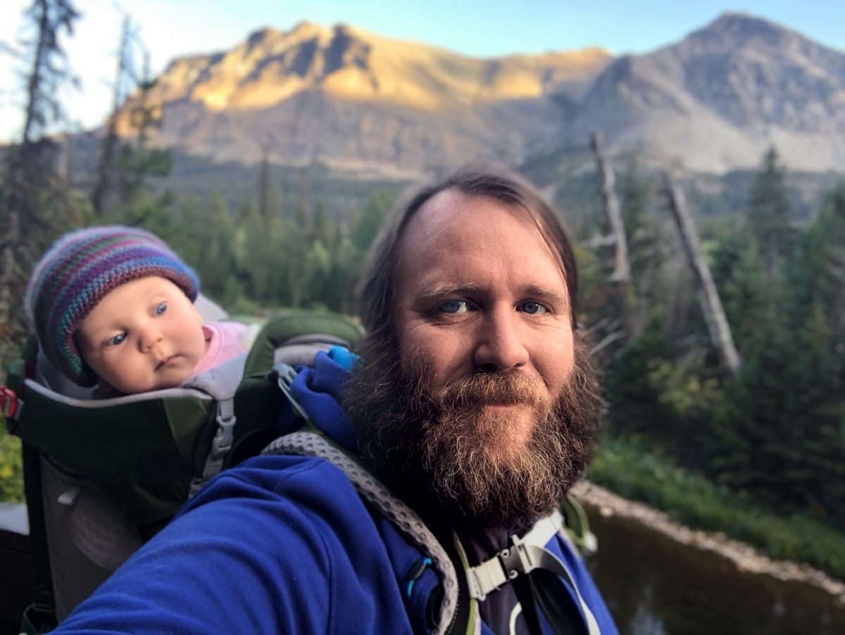 Photo of my daugher and I hiking in the mountains with her in a backpack looking forward.