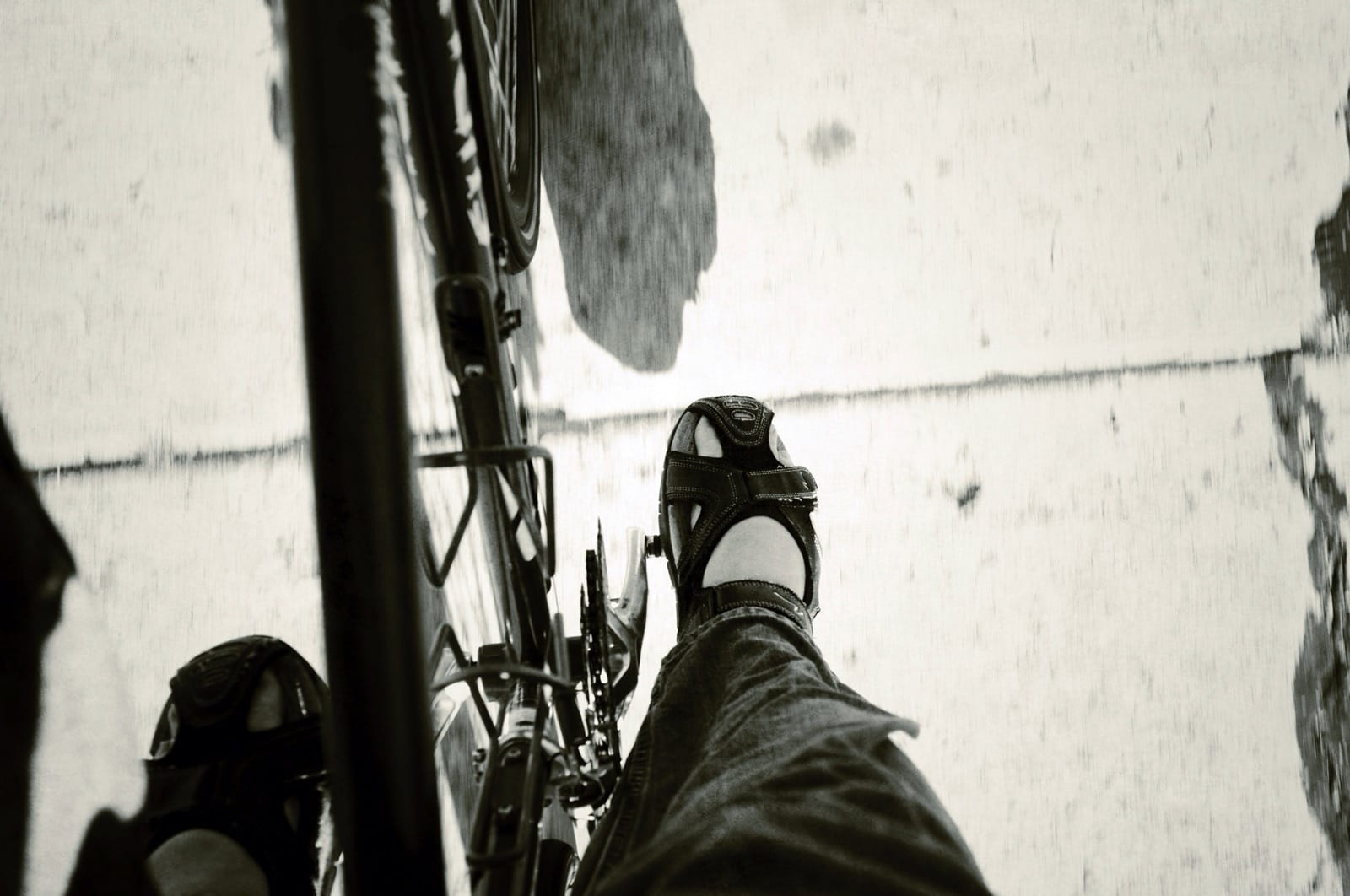 B&W photo of feet on a bicycle.